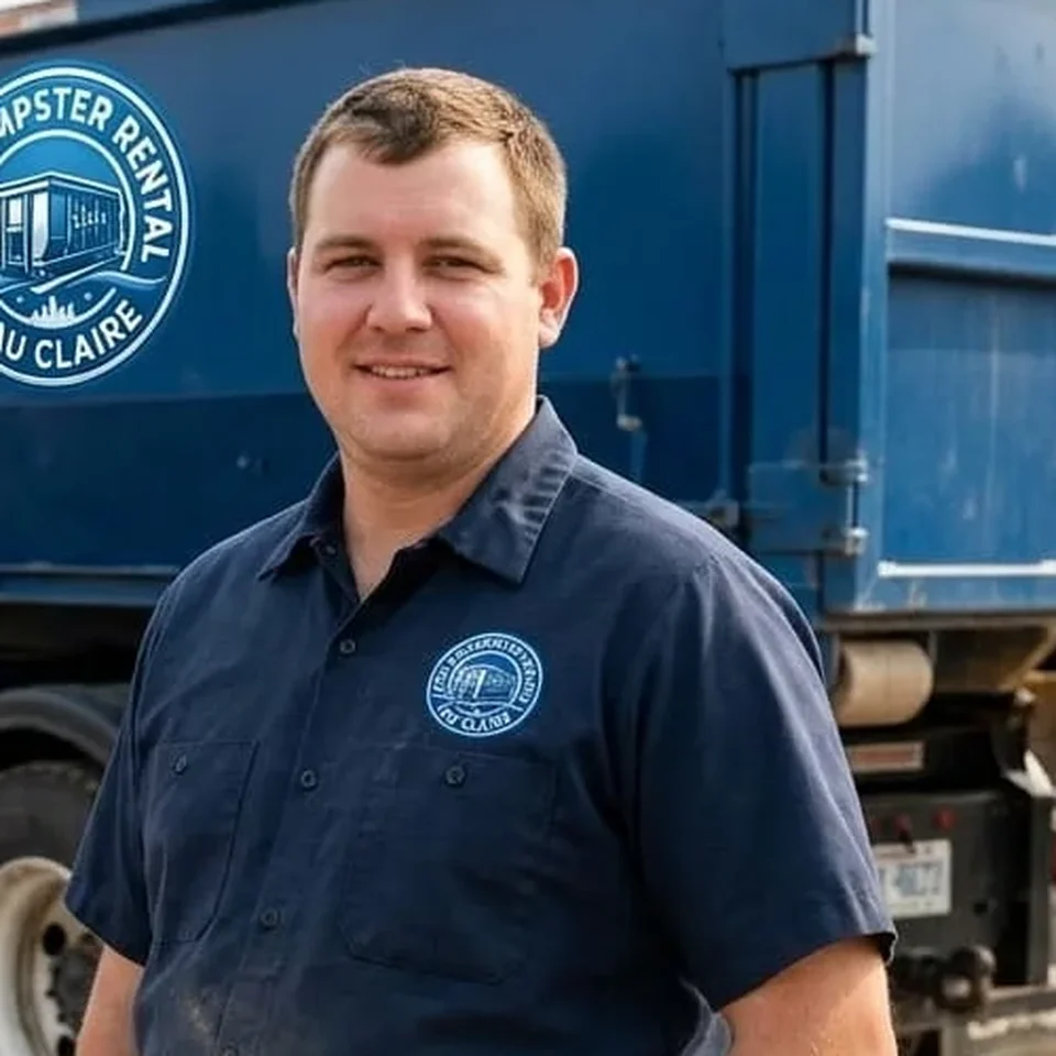 Kyle Anderson, Lead Driver at CHA Dumpster Rental Eau Claire, standing beside a company roll-off truck